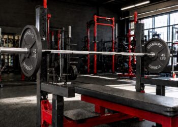 Close-grip bench press setup with a loaded Olympic barbell on a flat bench in a powerlifting gym, demonstrating a key exercise for building stronger triceps, improving bench press strength, and increasing upper-body power.