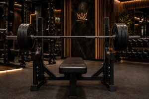 Powerlifting bench press setup with loaded barbell, flat bench, and rack in a luxury strength gym, highlighting control, stability, and grip for a bigger bench press.