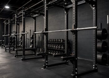 Powerlifting squat rack setup with loaded barbells, black power racks, weight plates, and strength training equipment for optimizing squat technique.